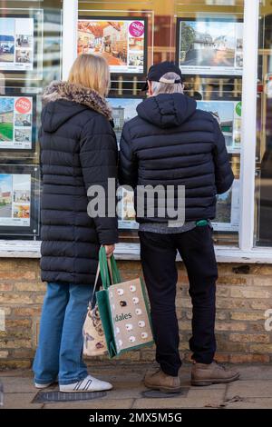 Foto datata febbraio 2nd mostra le persone che cercano nelle finestre degli agenti immobiliari a Ely, Cambs, il Giovedi mattina come è annunciato ci sarà un altro inc Foto Stock