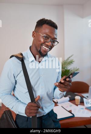 Il giovane uomo d'affari nero esce dalla sala conferenze sorridendo al telefono Foto Stock