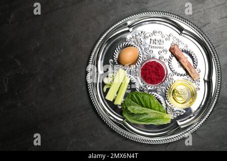 Piastra di sicurezza Passover (keara) su tavolo nero, vista dall'alto con spazio per il testo. Festa di Pesah Foto Stock