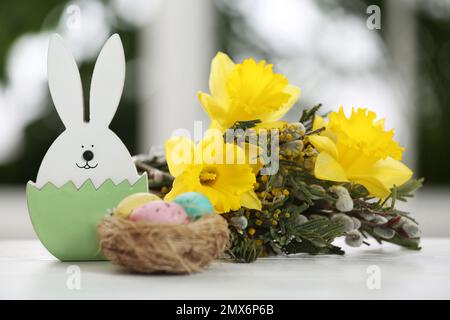 Composizione festiva con uova di Pasqua sul tavolo contro finestra sfocata Foto Stock