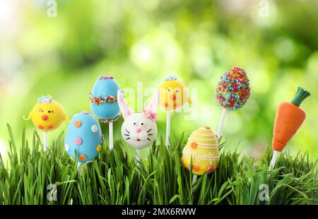 Diversi deliziosi pops torta per la celebrazione di Pasqua in erba su sfondo verde sfocato Foto Stock