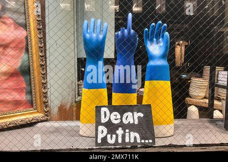 Un cartello di fronte alle mani manichine dipinte nei colori blu e giallo della bandiera Ucraina recita: "Caro Putin...” Il 17 gennaio 2023 a New York. Le mani visualizzano un dito centrale esteso. (Foto di Samuel Rigelhaupt/Sipa USA) Foto Stock