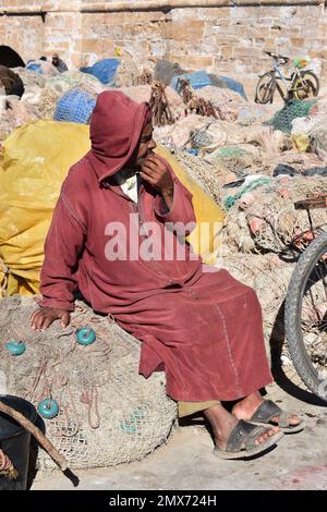 Vecchio locale seduto nel porto di Essaouira, Marocco Foto Stock