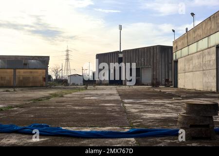 Complesso industriale abbandonato chiuso da un cancello nella campagna italiana Foto Stock