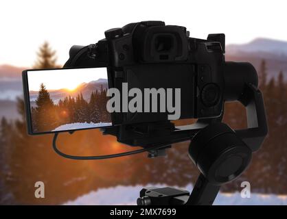 Registrazione di una splendida vista della foresta innevata con una videocamera professionale Foto Stock