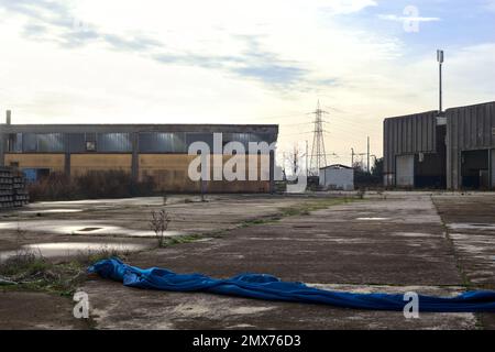 Complesso industriale abbandonato chiuso da un cancello nella campagna italiana Foto Stock