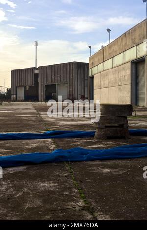 Complesso industriale abbandonato chiuso da un cancello nella campagna italiana Foto Stock