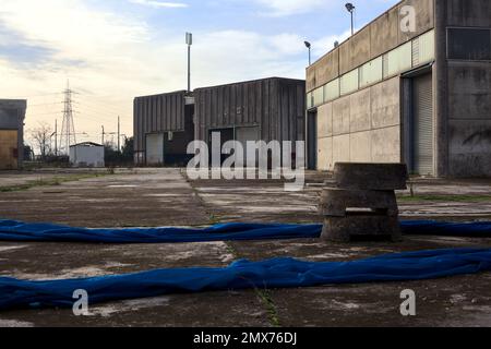 Complesso industriale abbandonato chiuso da un cancello nella campagna italiana Foto Stock