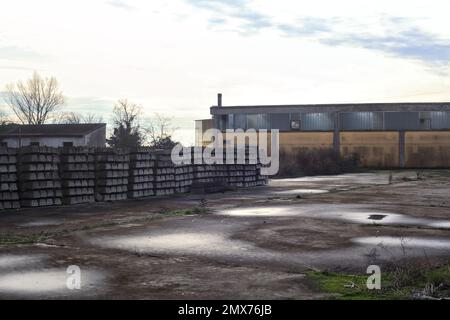 Complesso industriale abbandonato chiuso da un cancello nella campagna italiana Foto Stock