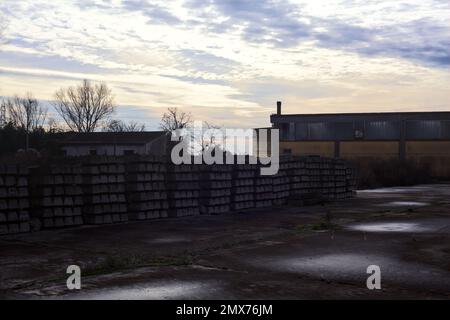 Complesso industriale abbandonato chiuso da un cancello nella campagna italiana Foto Stock