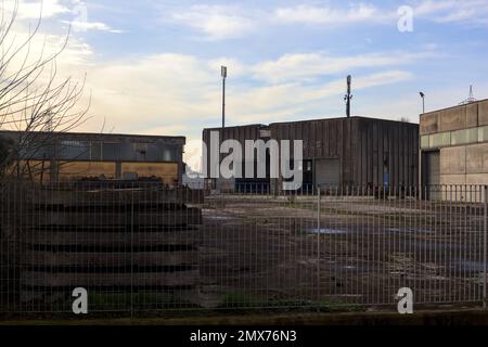 Complesso industriale abbandonato chiuso da un cancello nella campagna italiana Foto Stock