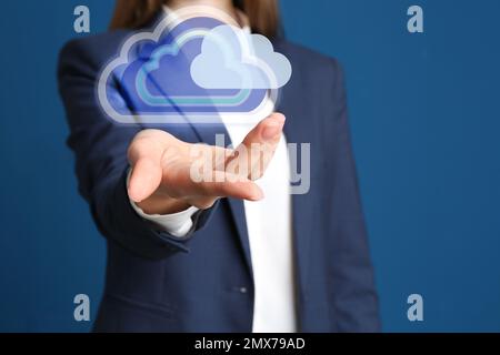 Donna con nuvole virtuali icona su sfondo blu, primo piano della mano. Concetto di memorizzazione dei dati Foto Stock