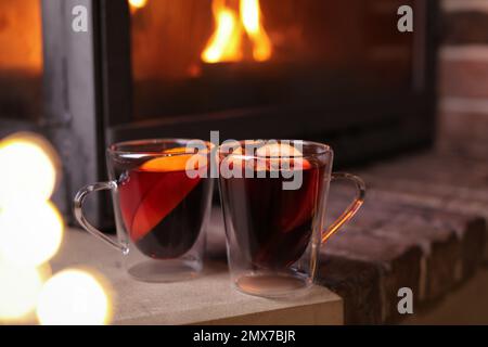 Gustoso VIN brulé in bicchieri di vetro vicino al camino interno Foto Stock