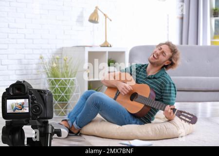 Insegnante di musica che registra la lezione di chitarra a casa Foto Stock