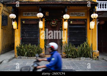 Hoi An Man in moto di fronte al tradizionale edificio - Hoi, An, Vietnam Foto Stock