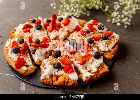 La Fregolotta, una tradizionale torta o torta di briciole italiana, è vista dall'alto su un tavolo, coperto di mascarpone, mirtilli rossi e lamponi. Traditio Foto Stock