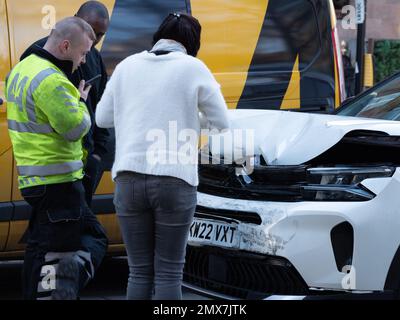 Il furgone di assistenza stradale AA e il meccanico forniscono assistenza al conducente in panne in caso di veicolo danneggiato da collisione parcheggiato lungo la strada Foto Stock