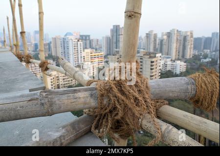 INDIA, Mumbai, torre di appartamenti in fase di ristrutturazione, impalcatura con pali di bambù legati con corde di iuta / INDIEN, Mumbai, Wohnhaus mit Baugerüst aus Bambus Foto Stock