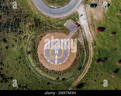 Vista aerea della strada tortuosa. Splendida scena mattutina di strada asfaltata. Eliporto per elicotteri di emergenza. Vista aerea dell'eliporto per l'elicottero di emergenza Foto Stock