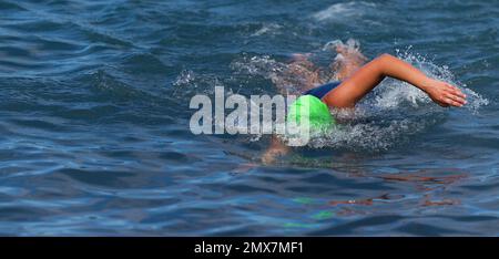 Triathlete donna nuoto crawl freestyle in oceano, triathlon femminile nuoto in triathlon professionale Foto Stock