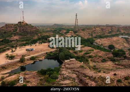 Vista dall'alto della città di Jodhpur con parcheggio auto, torri mobili e lago d'acqua accanto al forte di Mehrangarh, jodhpur, Rajasthan, India. Sfondo blu cielo. Foto Stock