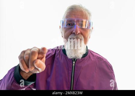 Ritratto di sicuro anziano portatore maschio in occhiali e vestito casual guardando la fotocamera mentre ti mostra gesti su sfondo bianco Foto Stock