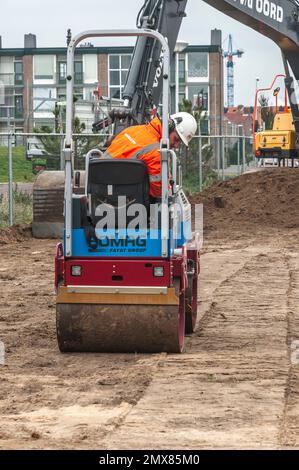 operatore a rulli di un rullo stradale durante il lavoro in cantiere Foto Stock