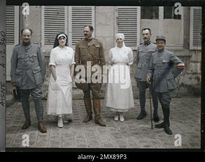 Soissons, Aisne, Francia medici francesi che circondano un ufficiale americano, Madame Mireille Andrieu indossare un velo di infermiere rosa e blu Georgette Saint-Paul, infermiera maggiore , 1917 - Aisne - Fernand Cuville (sezione fotografica dell'esercito) - (maggio-luglio) Foto Stock