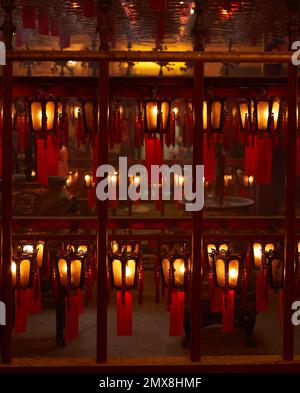 Lanterne rosse appese in fila in un tempio buddista di Hong Kong. Foto Stock