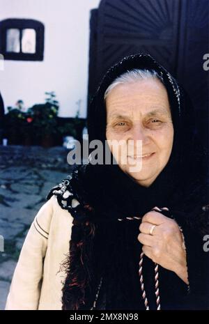 Poiana Sibiului, Sibiu County, Romania, 2000. Donna locale che indossa abiti tradizionali di pelle di pecora ('cojoca') in inverno. Foto Stock