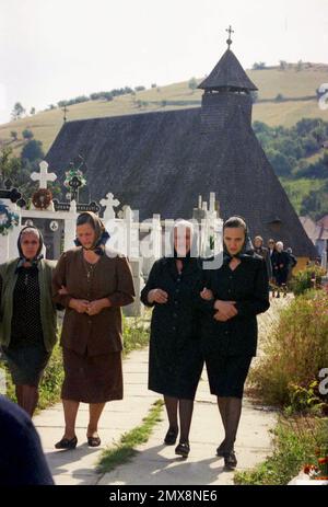 Poiana Sibiului, Sibiu County, Romania, 2000. I parrocchiani lasciano la chiesa alla fine del servizio domenicale. La chiesa cristiana ortodossa in legno, monumento storico del 1766. Foto Stock