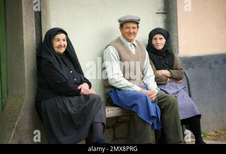 Abitanti del villaggio seduti su una panchina fuori una casa nella contea di Sibiu, Romania, circa 1999 Foto Stock