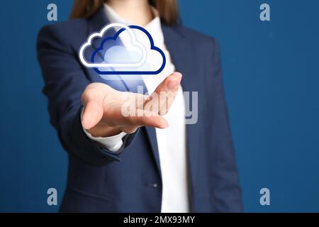 Donna con nuvole virtuali icona su sfondo blu, primo piano della mano. Concetto di memorizzazione dei dati Foto Stock