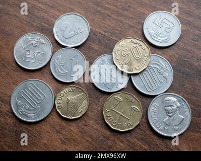 Moneta moneta di Uruguay su sfondo di legno, primo piano. Monete Nuevos peso e Centesimos. Concetto di svalutazione Foto Stock