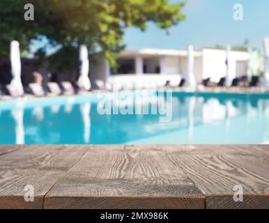 Terrazza in legno vicino alla piscina all'aperto nelle giornate di sole. Spazio per il testo Foto Stock