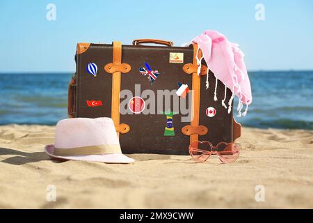 Valigia retro con adesivi da viaggio sulla spiaggia Foto Stock