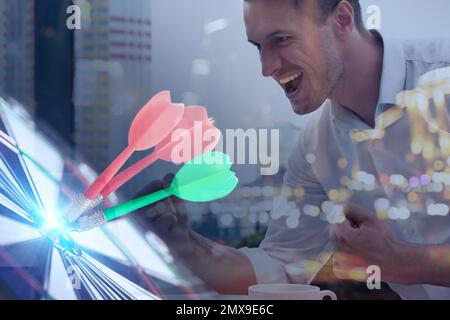 Uomo d'affari che lavora con computer portatile e dart board. Doppia esposizione Foto Stock