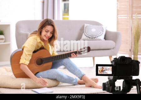 Insegnante di musica che registra la lezione di chitarra a casa Foto Stock