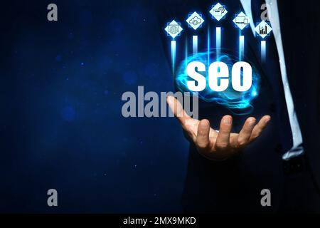 Uomo che dimostra le direzioni di SEO, primo piano. Icone di ricerca di parole chiave, personalizzazione e altri Foto Stock