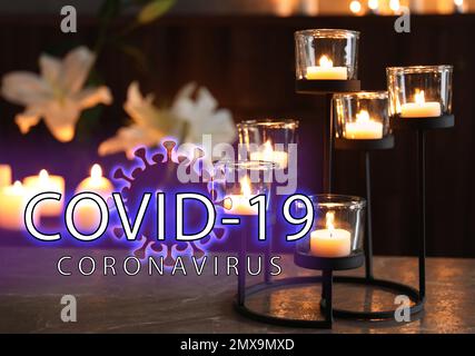 Cerimonia funebre dedicata alle vittime del coronavirus. Candele che bruciano sul tavolo Foto Stock