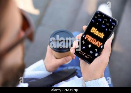 Black Friday. Uomo che acquista online con lo smartphone, primo piano Foto Stock
