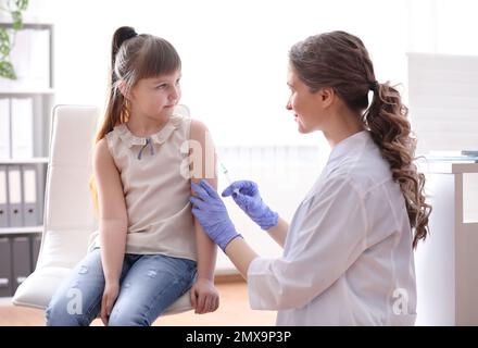 Bambina che riceve la vaccinazione contro la varicella in clinica. Prevenzione del virus della varicella Foto Stock