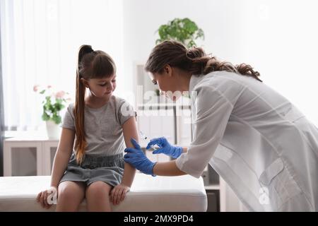 Bambina che riceve la vaccinazione contro la varicella in clinica. Prevenzione del virus della varicella Foto Stock