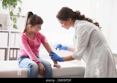 Bambina che riceve la vaccinazione contro la varicella in clinica. Prevenzione del virus della varicella Foto Stock