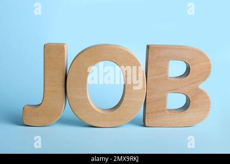 Lavoro di Word con lettere di legno su sfondo azzurro. Concetto di carriera Foto Stock