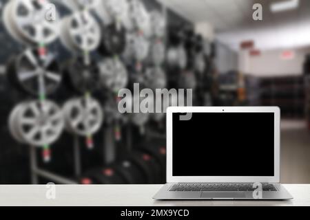 Moderno computer portatile sul tavolo in negozio auto. Spazio per il testo Foto Stock