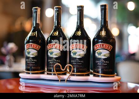 LVIV, UCRAINA - 26 OTTOBRE 2022: Baileys Irish Cream quattro bottiglie di vetro su uno stand di marca con illuminazione Foto Stock