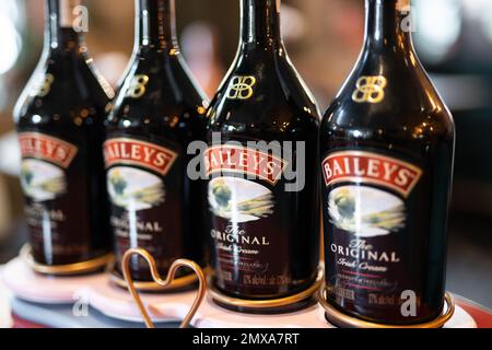 LVIV, UCRAINA - 26 OTTOBRE 2022: Baileys Irish Cream quattro bottiglie di vetro su uno stand di marca con illuminazione Foto Stock