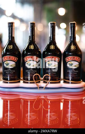 LVIV, UCRAINA - 26 OTTOBRE 2022: Baileys Irish Cream quattro bottiglie di vetro su uno stand di marca con illuminazione Foto Stock