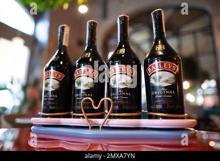 LVIV, UCRAINA - 26 OTTOBRE 2022: Baileys Irish Cream quattro bottiglie di vetro su uno stand di marca con illuminazione Foto Stock